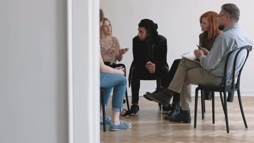Teenagers and Psychotherapist Listening to Young Woman While Sitting in the Circle