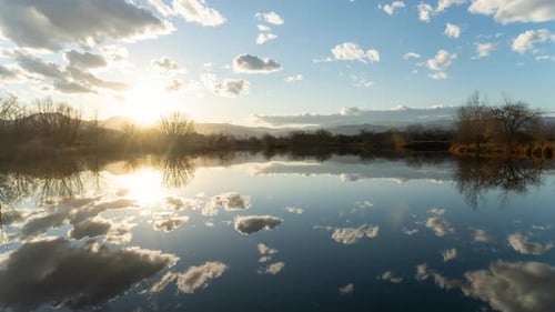 Zeitraffer der Reflexion von Wolken und Sonnenuntergang über dem Spiegelsee