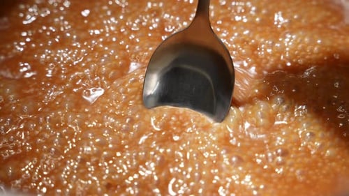 Liquid Boiling with Bubbles Being Stirred with Spoon