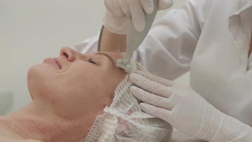 Adult Woman Receives Facial Treatment with Machine