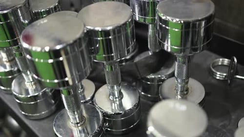 Dumbbells Differing in Weight and Size Placed on Tabletop in Gym