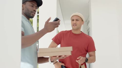 Courier delivering pizza boxes checking phone confirming with customer at door holding paper bag