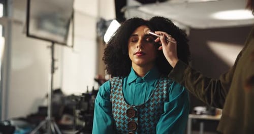 Woman Getting Makeup Applied in Studio Setting