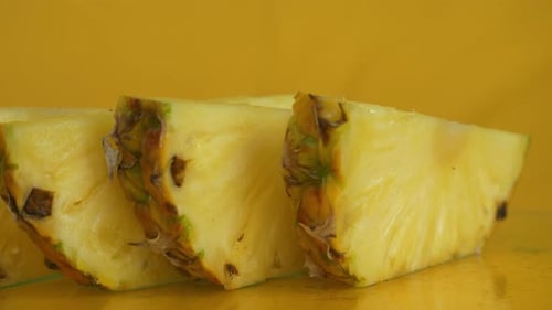 Pineapple Slices Displayed on a Vibrant Yellow Background
