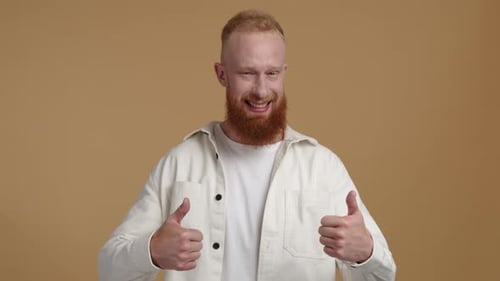 Caucasian Redhaired Man Looks Happy and Cheerful While Working in the Studio