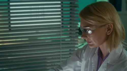 Scientist Examining Blue Liquid in Laboratory Flask