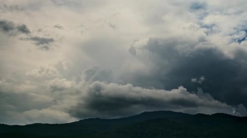 Timelapse of the Rainy Clouds Moving in the Blue Sky Above the Hills