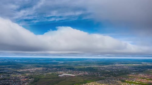 Aerial high altitude timelapse of the sky with fast moving clouds. Hyperlapse over the rural area wi