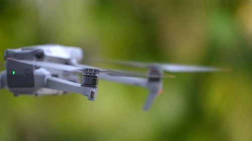 Zumbido con cámara digital y hélices de rotación rápida volando tomando Vídeo y fotografías