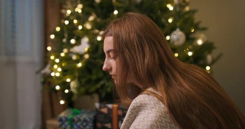Woman Drinking from Mug Near Christmas Tree