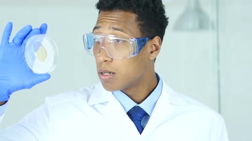 Medical Scientist Studying Reaction in Watch Glass in Laboratory