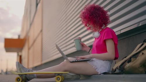 Woman Working on Laptop with Skateboard