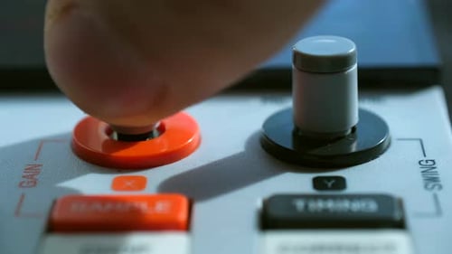 Finger Pushing Gain Knob on a Gray Device