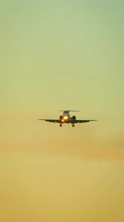Aeronave descendo com faróis acesos e trem de pouso: jato particular estendido se aproximando da pista