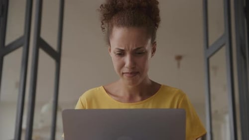 Low Angle Shot of an African American Woman in Aspirations Working on Her Laptop Indoors
