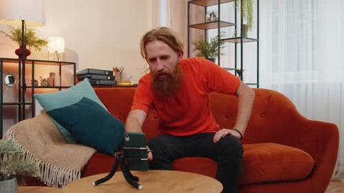Bearded Man Talking to Smartphone on Couch