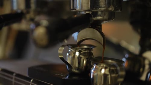 Espresso Machine Pouring Coffee into a Silver Pitcher