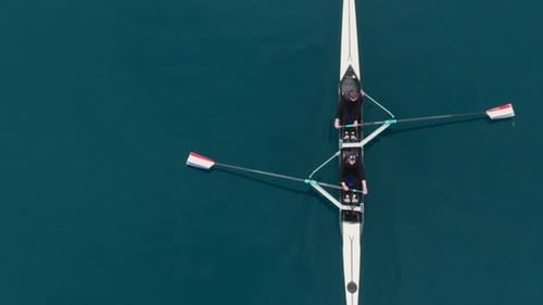Two Athletes Rowing a Sculling Boat on Calm Blue Water Teamwork and Endurance in Competitive Sport