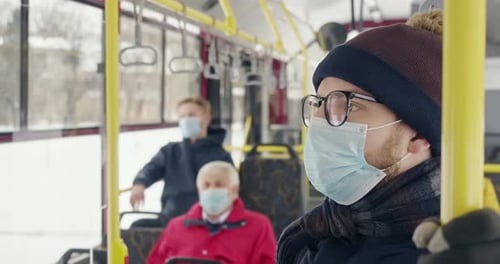 Man Wearing Mask Riding City Bus in Winter