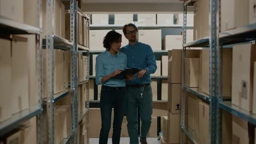Female Inventory Manage and Storage Worker, Check Stock and Have Discussion at Work. In the Backgro