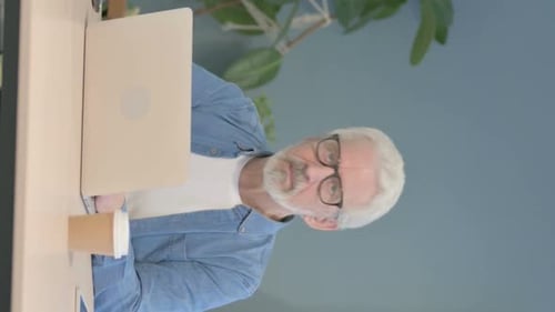 Senior Man Working at Laptop in Home Office