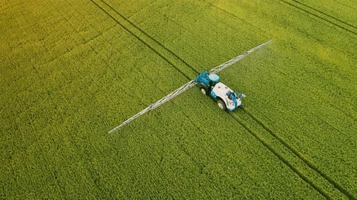 Aerial View Farming Tractor Spraying on Field with Sprayer Herbicides and Pesticides Farm Machinery