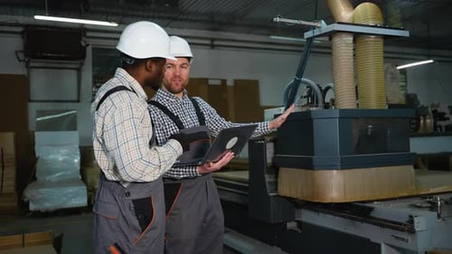 Two Workers Monitor CNC MDF Cutting Machine Operation