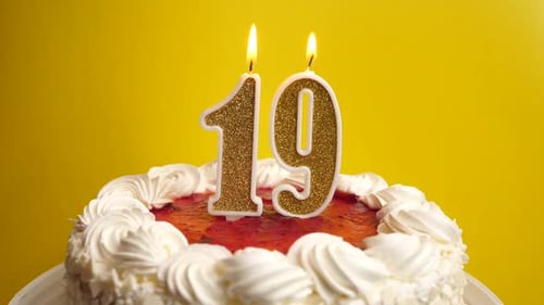 19. A candle in the form of the number 19, inserted into the holiday cake, is blown out. Celebrating