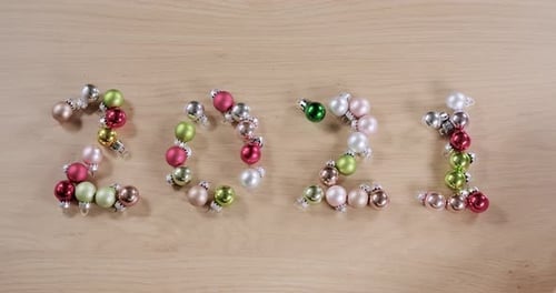 new year twenty twenty one written with Christmas balls wiped away by a hand