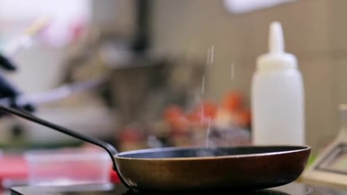 Chef Cooking Food in a Pan with Tongs