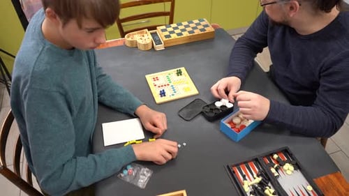 Teen and Adult Prepare for Board Game at Table