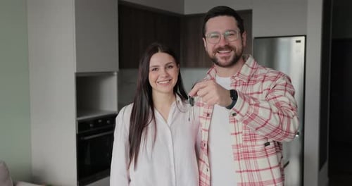 Happy Couple Owners of a New Apartment Show the Key Looking at the Camera Buying First Family Real