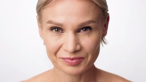 Blonde Woman Smiling Elegantly on a White Background