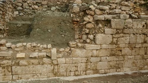 Wall of large stones from an ancient building at the base of the mountain, panoramic view.