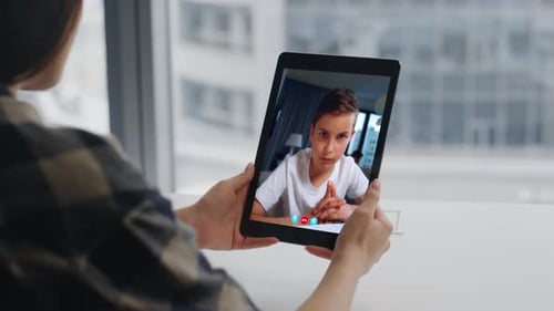 Woman using Tablet to Video Chat with Boy