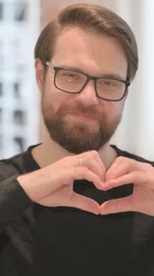 Man in Glasses Making Heart Shape with Hands