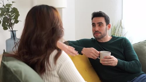 Man Chatting with Woman on Sofa at Home