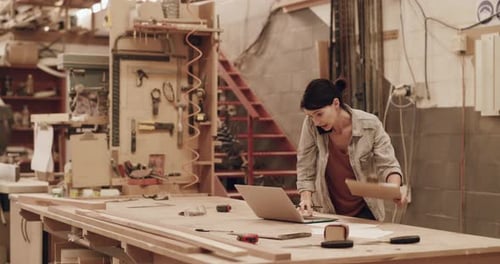4k video footage of an attractive young female carpenter working in her woodworking workshop