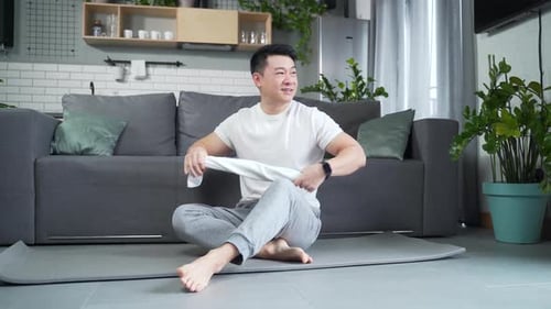 Young Man Relaxing After Exercising at Home