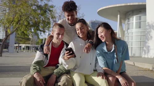Group of Trendy Young People Chatting Together Sitting Outdoors