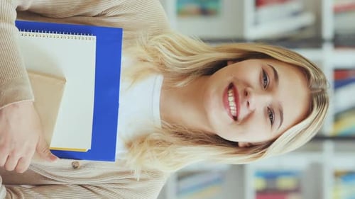 Young Woman Student Holding Books and Smiling