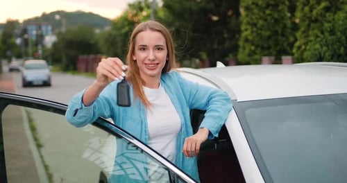 Young Woman With Car Keys Near White Car