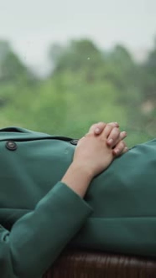 Woman's Hand Resting While Travelling on Rainy Day