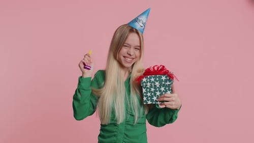 Excited Woman Celebrates Birthday with Gift and Noisemaker