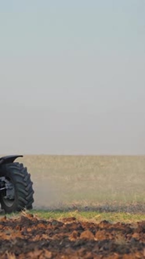 Tractor plows a field. Close up of tractor cultivating field