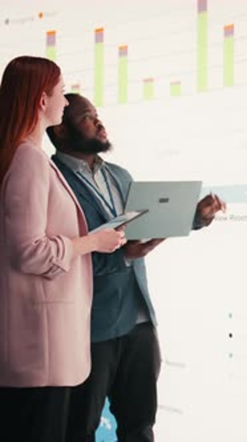 Vertical Video Analyzing Economic Data Graphs Laptop and Businesspeople