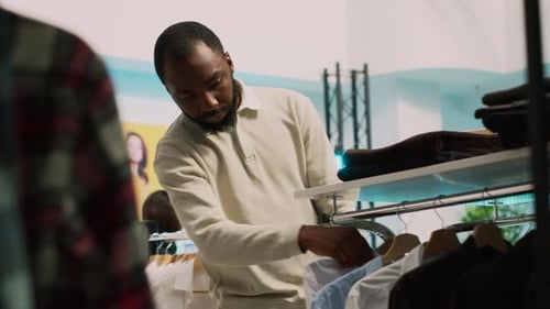 Client afro-américain ramassant des vêtements sur des cintres