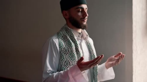 Close-up shot of a Muslim man's hands praying on his knees during Ramadan in Islamic temple