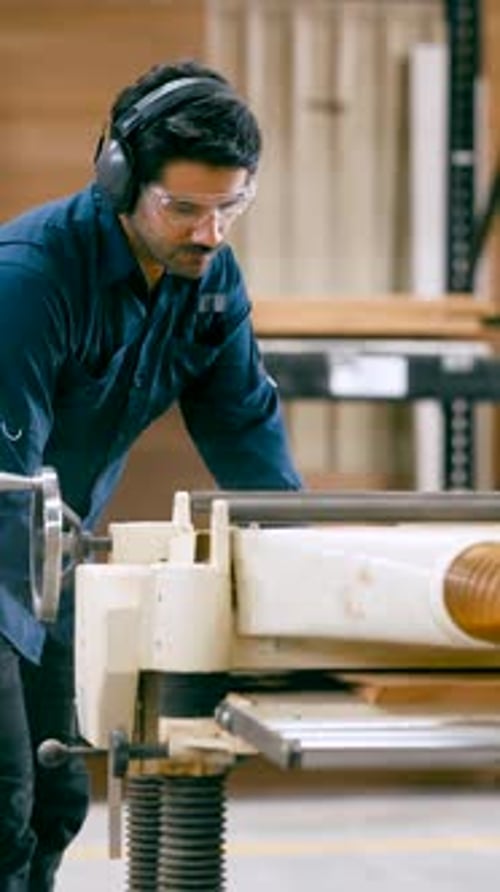 Professional Carpenter Planing Wood Board in a Workshop Vertical