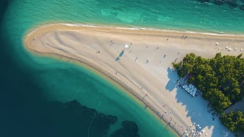 Voo de Drone sobre a faixa costeira, as árvores e a praia na cidade turística da Croácia, às margens